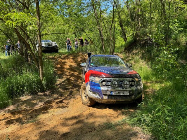 Tischer_Treffen_25_Ford Ranger mit Tischer Kabine bei einer Offroad-Testfahrt im Wald – Zuschauer im Hintergrund.
