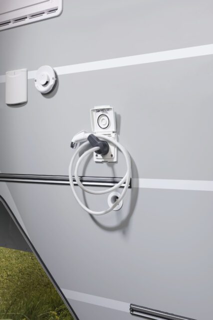 Außendusche mit Schlauch und Duschkopf an der Seitenwand einer Tischer-Kabine.