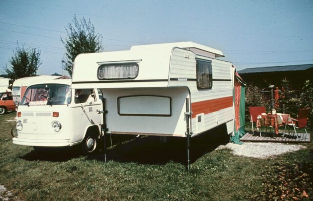1973_Tischer-Kabine auf Oldtimer-Pick-up – geparkt auf Campingplatz mit Vorzelt und Wäscheleine.