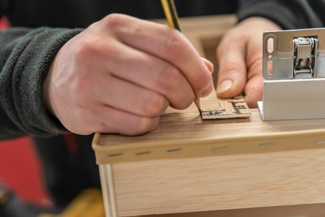 Hand zeichnet Markierung auf Holzelement – Detailaufnahme aus der Tischer Manufaktur