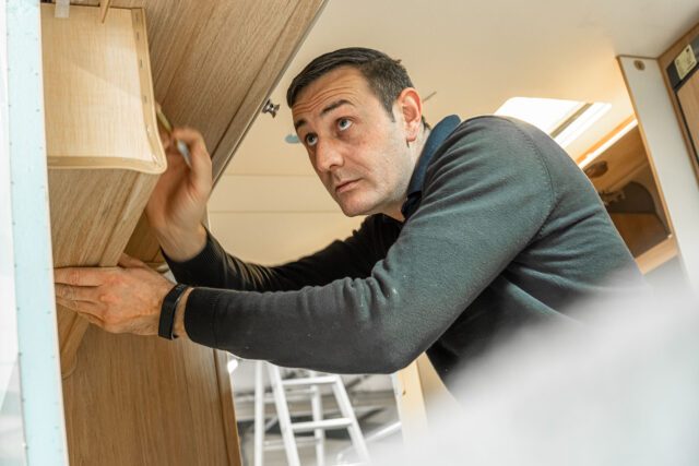 In der Schreinerei der Tischer Manufaktur wird die Seitenwand einer Kabine millimetergenau vermessen.