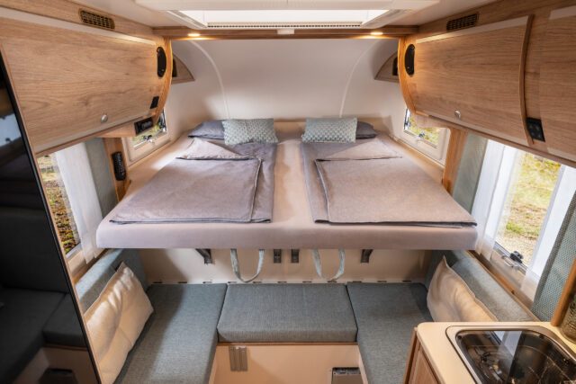 Tischer Trail230S- Innenraum einer Wohnkabine mit Doppelbett und hellem Holzdekor