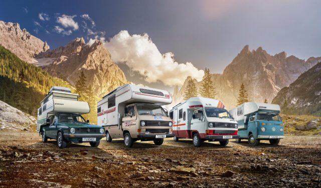 Vier klassische Tischer-Kabinen auf Pick-ups, geparkt vor einer alpinen Bergkulisse.