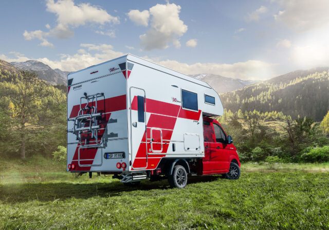 Seitenansicht der Tischer Box 340S mit MAN TGE, Fahrradträger und Aufstiegstreppe sichtbar.