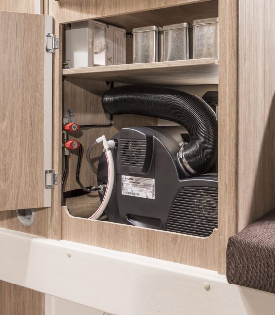 TRUMA-Combi-4E-Gasheizung in einer Tischer Kabine – sauber verstaut mit Schlauchsystem.