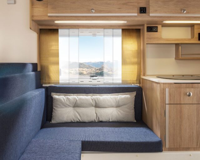 Innenraum Tischer Kabine mit blauen Polstern und goldgelben Vorhängen.