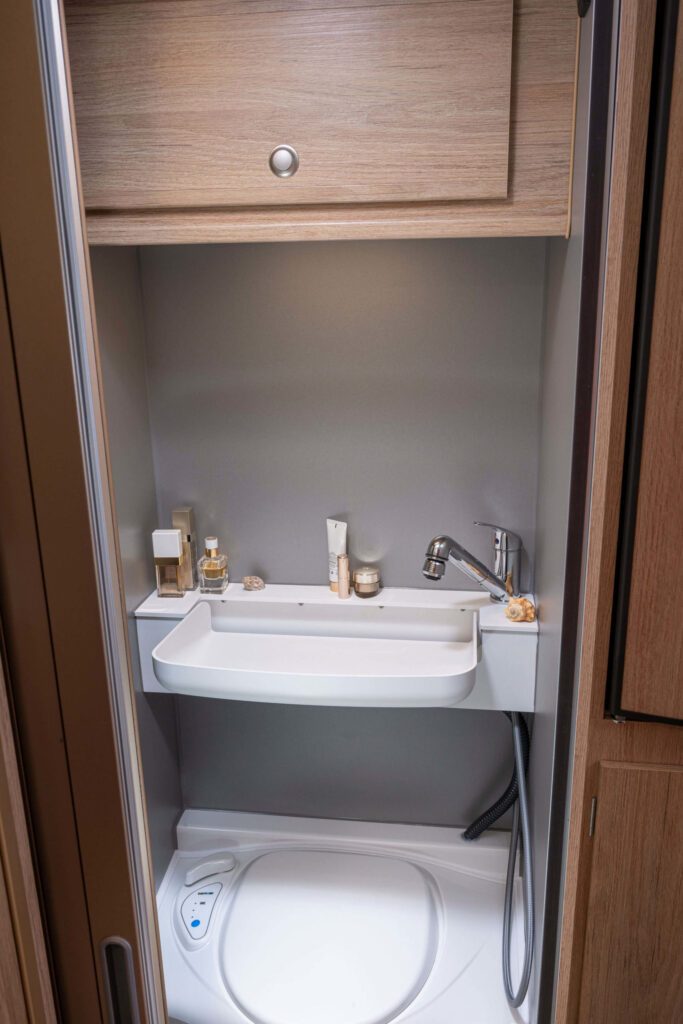 Tischer_230S_Bad-Waschbecken heruntergeklappt mit sichtbarer Armatur und Ablage