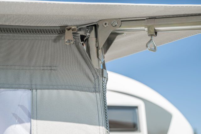 Reißverschluss und Haltesystem am oberen Eckbereich des Tischer Vorzelts – Verbindung zur Kabine.