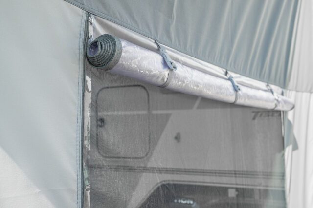 Aufgerollte Seitenwand mit Netzfenster am Tischer Vorzelt – Belüftung mit Sichtschutz.