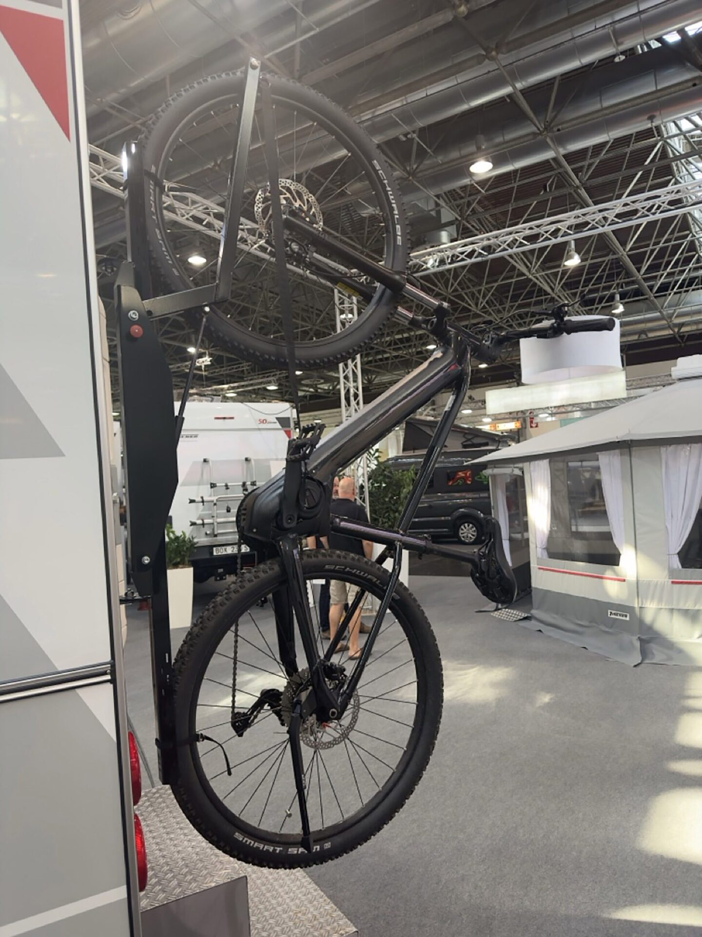 Seitenansicht mit montierten Fahrrädern am Trägersystem der Tischer Wohnkabine auf Messegelände.