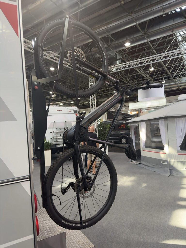 Seitenansicht mit montierten Fahrrädern am Trägersystem der Tischer Wohnkabine auf Messegelände.