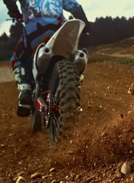 tischer_mieten_Dynamische Nahaufnahme eines Offroad-Motorrads beim Fahren auf losem Untergrund – Abenteuergeist passend zum Tischer-Lifestyle.