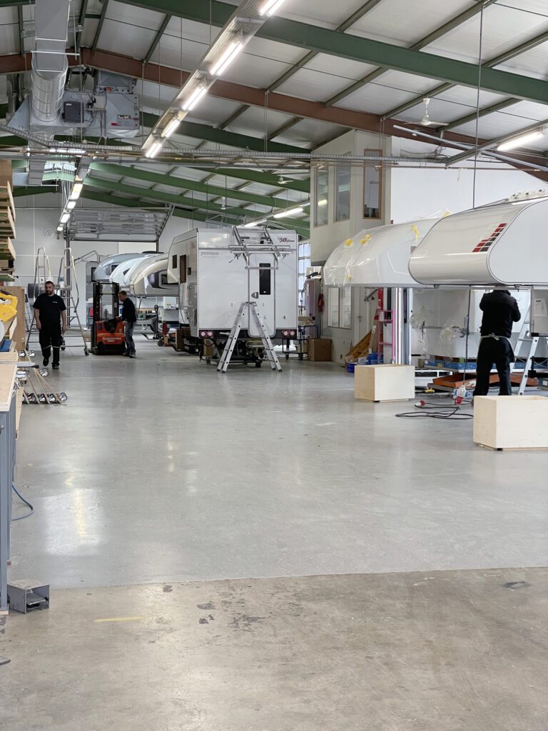 tischer_werkstatt_box_trail_Blick in die Produktionshalle – mehrere Wohnkabinen in verschiedenen Baustufen.