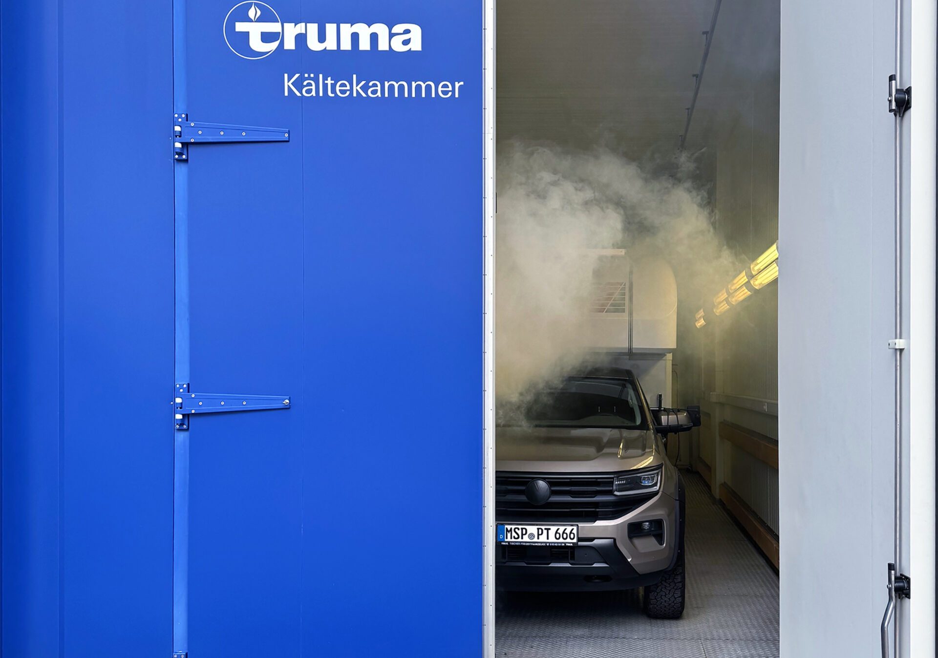 Tischer-Fahrzeug in blauer Kältekammer von Truma – Sicht auf simulierte Kälteprüfung.